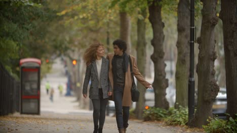 Pareja-romántica-caminando-en-la-calle-de-otoño-en-la-ciudad-en-cámara-lenta