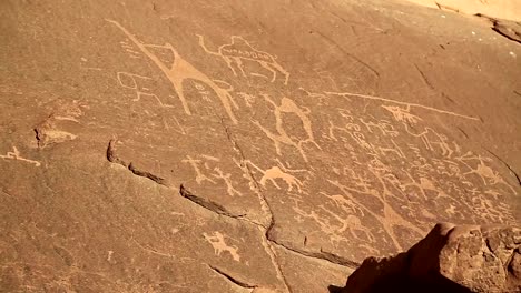 Alten-Felszeichnungen,-die-Darstellung-von-Menschen-und-Kamelen-in-der-Wüste-Wadi-Rum,-Jordanien