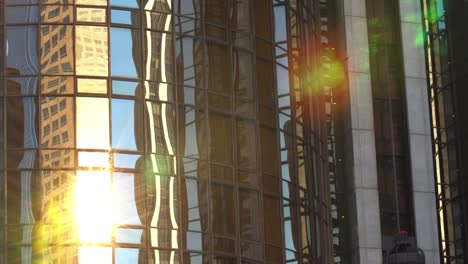 Moderne-Bürogebäude-Glasaufzug-in-Sonnenstrahlen-nach-unten-bewegen