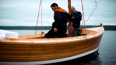 Master-und-sein-Assistent-arbeiten-auf-Holz-Segelboot