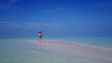 v03893-fliegenden-Drohne-Luftaufnahme-der-Malediven-weißen-Sandstrand-2-Personen-junges-Paar-Mann-Frau-romantische-Liebe-auf-sonnigen-tropischen-Inselparadies-mit-Aqua-blau-Himmel-Meer-Wasser-Ozean-4k