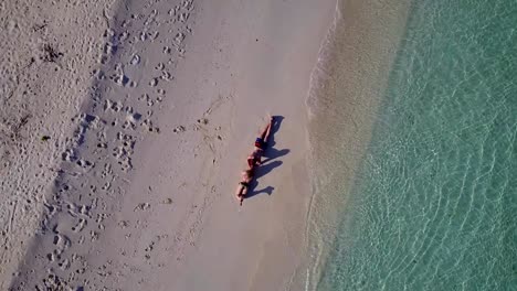 v03890-fliegenden-Drohne-Luftaufnahme-der-Malediven-weißen-Sandstrand-2-Personen-junges-Paar-Mann-Frau-romantische-Liebe-auf-sonnigen-tropischen-Inselparadies-mit-Aqua-blau-Himmel-Meer-Wasser-Ozean-4k