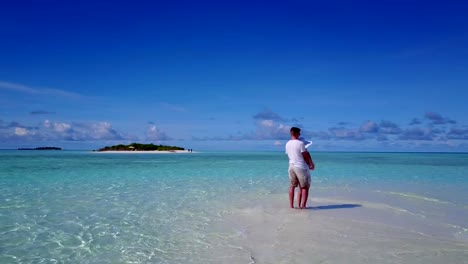 v03943-vuelo-drone-vista-aérea-de-Maldivas-playa-2-personas-pareja-hombre-mujer-amor-romántico-en-la-isla-de-paraíso-tropical-soleado-con-cielo-azul-aqua-agua-mar-4k