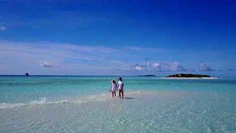 v03945-fliegenden-Drohne-Luftaufnahme-der-Malediven-weißen-Sandstrand-2-Personen-junges-Paar-Mann-Frau-romantische-Liebe-auf-sonnigen-tropischen-Inselparadies-mit-Aqua-blau-Himmel-Meer-Wasser-Ozean-4k