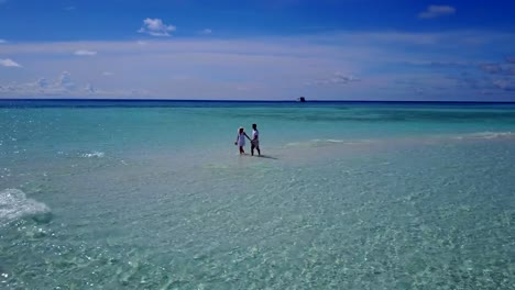 v03911-vuelo-drone-vista-aérea-de-Maldivas-playa-2-personas-pareja-hombre-mujer-amor-romántico-en-la-isla-de-paraíso-tropical-soleado-con-cielo-azul-aqua-agua-mar-4k