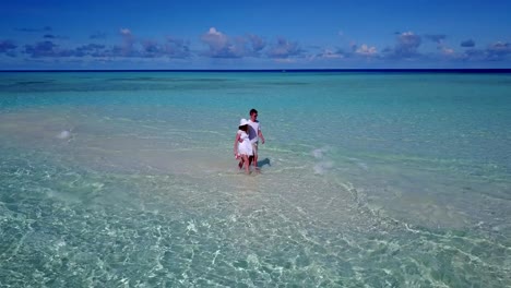 v03910-fliegenden-Drohne-Luftaufnahme-der-Malediven-weißen-Sandstrand-2-Personen-junges-Paar-Mann-Frau-romantische-Liebe-auf-sonnigen-tropischen-Inselparadies-mit-Aqua-blau-Himmel-Meer-Wasser-Ozean-4k