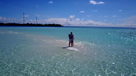 v03930-vuelo-drone-vista-aérea-de-Maldivas-playa-2-personas-pareja-hombre-mujer-amor-romántico-en-la-isla-de-paraíso-tropical-soleado-con-cielo-azul-aqua-agua-mar-4k