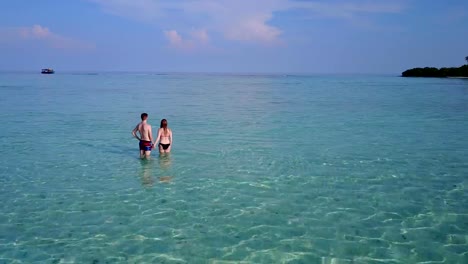 v03992-vuelo-drone-vista-aérea-de-Maldivas-playa-2-personas-pareja-hombre-mujer-amor-romántico-en-la-isla-de-paraíso-tropical-soleado-con-cielo-azul-aqua-agua-mar-4k