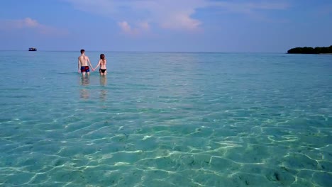 v04039-fliegenden-Drohne-Luftaufnahme-der-Malediven-weißen-Sandstrand-2-Personen-junges-Paar-Mann-Frau-romantische-Liebe-auf-sonnigen-tropischen-Inselparadies-mit-Aqua-blau-Himmel-Meer-Wasser-Ozean-4k