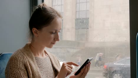 Woman-travelling-by-bus-and-using-smartphone