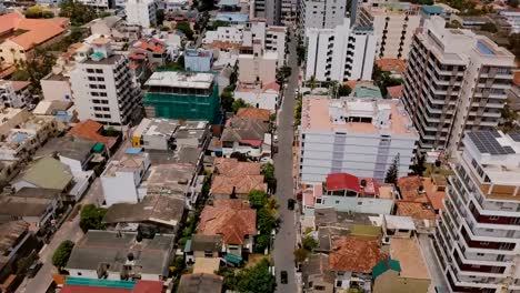 Drone-flying-backwards-over-the-town-of-Colombo,-Sri-Lanka.-Aerial-view-of-Asian-cityscape-with-modern-and-old-buildings