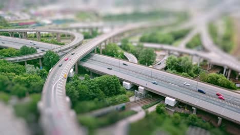 Luftaufnahme-von-einer-komplexen-Autobahn-Kreuzung-mit-Verkehr-bewegen-und-Tilt-Shift-Effekt