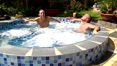 Couple-relaxes-in-the-hot-tub.-Woman-gets-up-and-goes