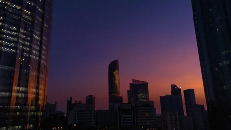 Hermosa-puesta-de-sol-mágica-con-la-luna-en-la-ciudad-de-Abu-Dhabi,-Emiratos-Árabes-Unidos