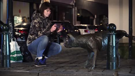 Lady-tourist-pictures-urinating-dog-in-Brussels,-Belgium.-Zinneke-pis