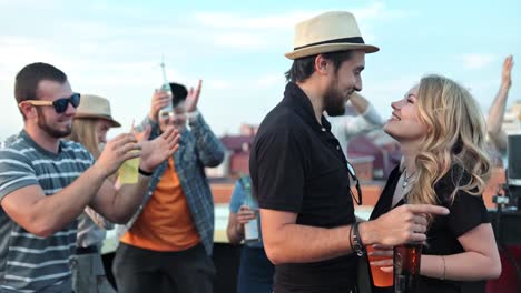 Hermosa-joven-pareja-riéndose-y-besándose-apasionadamente-en-la-fiesta-de-verano-en-la-azotea