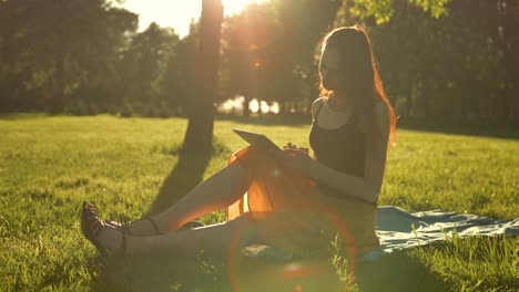 Young-lady-using-tablet-computer-outdoors