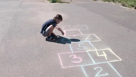 Boy-is-drawing-hopscotch-on-the-asphalt.