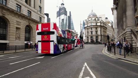 Britische-Flagge-Doppeldecker-Busse-vorbei-während-der-morgendlichen-Rushhour-im-Finanzdistrikt-London,-UK.