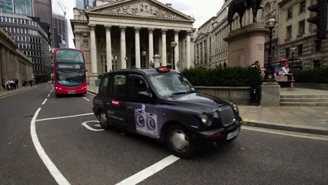 Schwarzes-Taxi-und-roten-Doppeldecker-Busse-im-morgendlichen-Berufsverkehr-im-Geschäftsviertel-in-London,-Vereinigtes-Königreich.