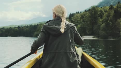 Mädchen-Reisenden-schwimmt-im-Boot-am-Bergsee.