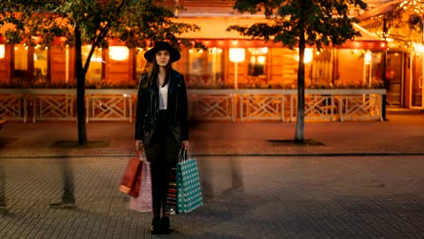 Time-Lapse-junge-Frau-Shopaholic-stehen-draußen-auf-der-Straße-mit-Einkaufstüten-und-Blick-in-die-Kamera-während-der-Zustrom-von-Menschen-bewegt-um-sie-herum.