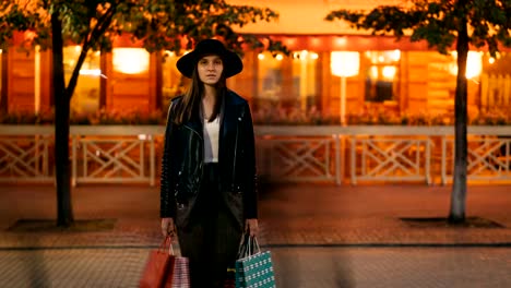 Time-lapse-portrait-of-tired-female-shopper-beautiful-woman-standing-with-paper-bags-in-the-street-and-looking-at-camera-while-people-are-moving-around-in-hurry.