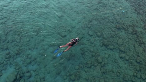 Aerial-view-of-a-spear-fisherman-swims-in-the-sea-to-catch-fish