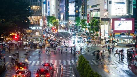Stadtteil-Shibuya-in-der-regnerischen-Nacht-mit-Publikum-vorbeigehen-Zebrastreifen.-Tokio,-Japan.--4K-Zeitraffer.