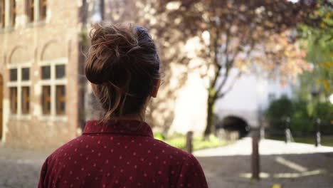 Chica-caminando-entre-pared-de-ladrillo