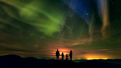 The-family-standing-on-the-mountain-on-the-northern-light-background.-time-lapse