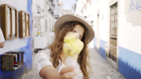 Sonriente-mujer-comiendo-helados-en-la-calle-de-la-ciudad