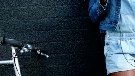 Woman-having-coffee-while-leaning-against-wall-4k