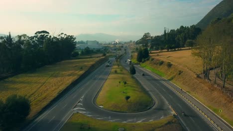 Vista-aérea-de-una-carretera-en-Colombia-incluyendo-montañas,-tráfico-y-el-lado-del-campo