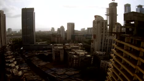 Bombey-skyscrapers-far-Arabian-sea-sun-shines-trough-clouds-in-sky-top-view