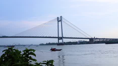 4K-Timelapse-hermosas-nubes-sobre-la-ciudad-de-Calcuta-con-una-vista-del-puente-Vidyasagar-o-puente-Seconf-Hooghly-en-el-río-Ganges,-Bengala-Occidental,-India.