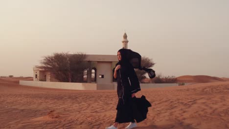 Muslim-woman-standing-near-mosque-in-the-desert.-Strong-wind-Middle-East-peace-without-war