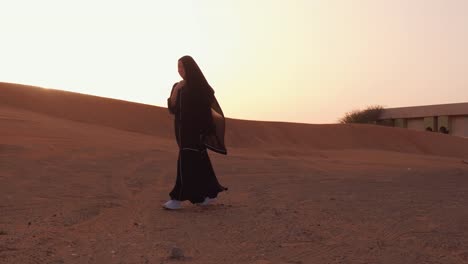 Mujer-musulmana-de-pie-cerca-de-la-mezquita-en-el-desierto.-Viento-fuerte-Paz-de-Oriente-Medio-sin-guerra