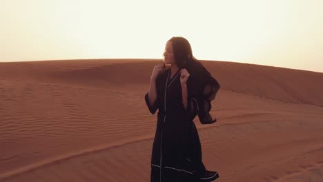 Muslim-woman-standing-near-mosque-in-the-desert.-Strong-wind-Middle-East-peace-without-war