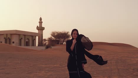 Muslim-woman-standing-near-mosque-in-the-desert.-Strong-wind-Middle-East-peace-without-war