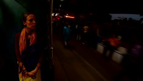 woman-near-open-doors-in-moving-train-railway-station-of-Kolkata-huge-crowd-evening