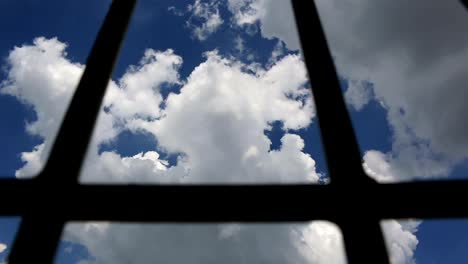 Prison-bars-and-blue-sky,-dolly-shot