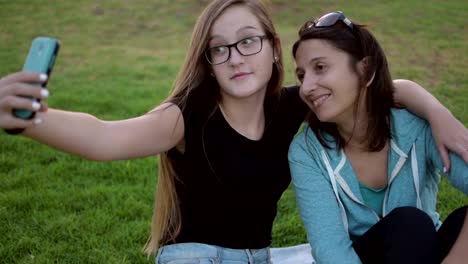 Teenage-girl-with-her-mother-taking-self-ie-in-the-park