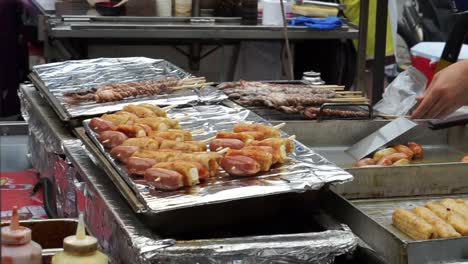 Eomuk,-Korean-street-food.-Fried-fish-cake,-sausage-and-hot-dog-on-stick-with-red-sauce-in-Seoul,-Korea