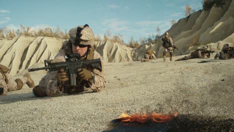 Escuadrón-de-soldados-completamente-equipados-y-armados-arrastrándose-durante-operación-militar-en-el-desierto.-Cámara-lenta.