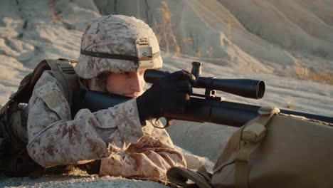 Close-up-of-Sniper-Lies-Down-on-the-Hill-and-Aims-through-the-Rifle-Scope-in-Desert-Environment