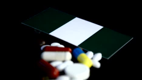 Nigerian-flag-with-lot-of-medical-pills-isolated-on-black-background