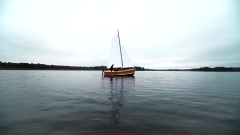 Maestro-y-ayudante-trabajando-en-velero-en-el-agua