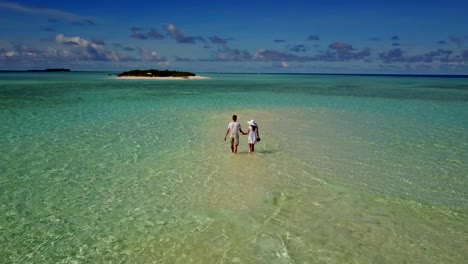 v03906-fliegenden-Drohne-Luftaufnahme-der-Malediven-weißen-Sandstrand-2-Personen-junges-Paar-Mann-Frau-romantische-Liebe-auf-sonnigen-tropischen-Inselparadies-mit-Aqua-blau-Himmel-Meer-Wasser-Ozean-4k