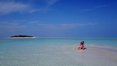 v03960-vuelo-drone-vista-aérea-de-Maldivas-playa-2-personas-pareja-hombre-mujer-amor-romántico-en-la-isla-de-paraíso-tropical-soleado-con-cielo-azul-aqua-agua-mar-4k